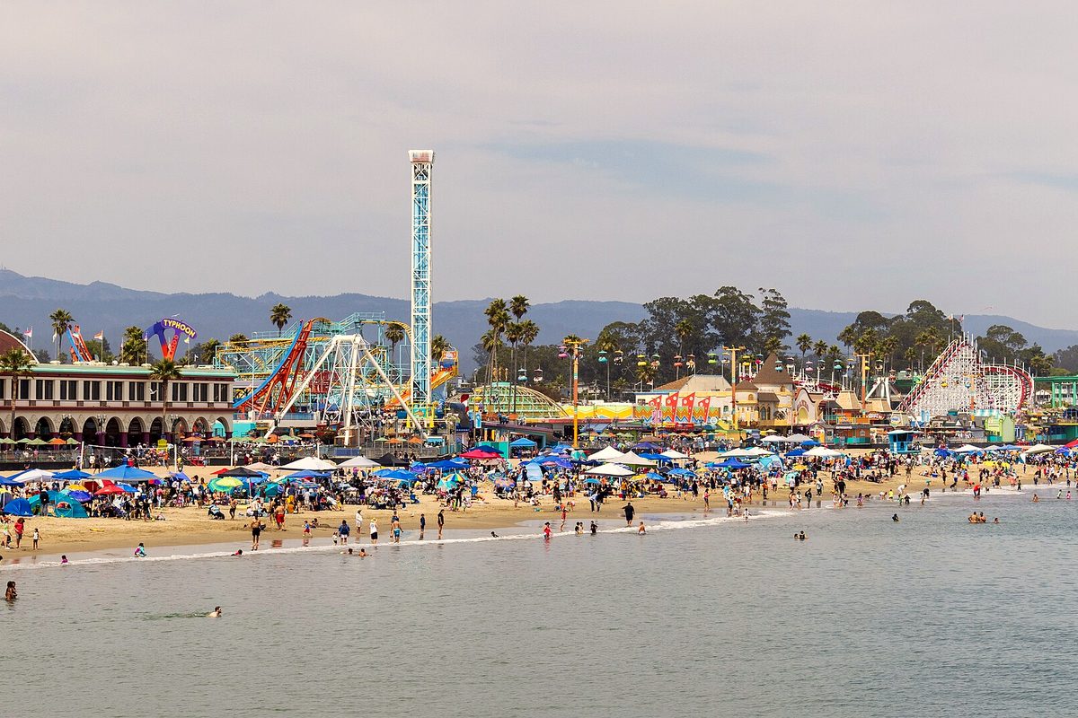 The Santa Cruz Beach Boardwalk and its rides seen from the beach on a summer day